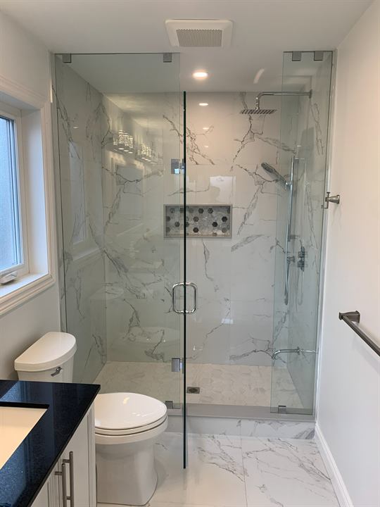 Walk-in shower with frameless glass, rain head and mosaic niche