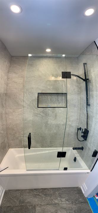 Tub and shower with frameless glass and matte black fixtures