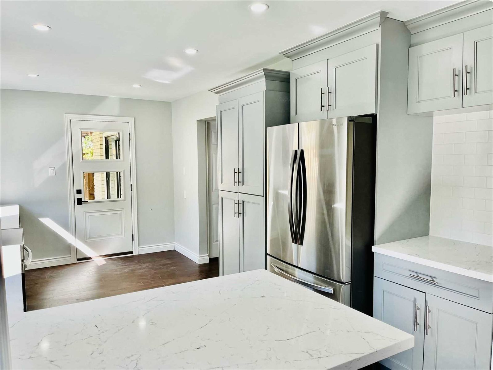 Renovated kitchen with shaker cabinets and a quartz island