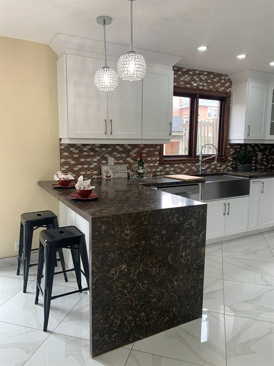 Kitchen with a waterfall quartz island and pendant lights