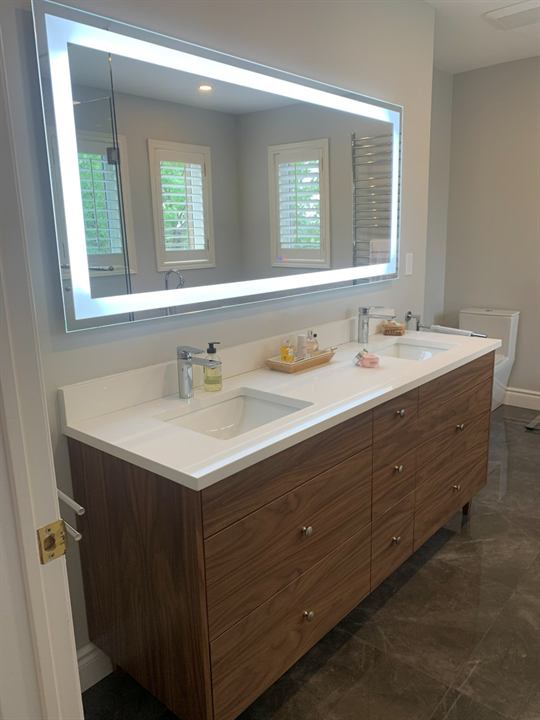Master bathroom with walnut double vanity and backlit LED mirror