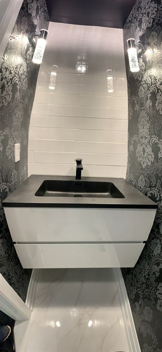 Powder room makeover with floating vanity, feature wallpaper and sconces